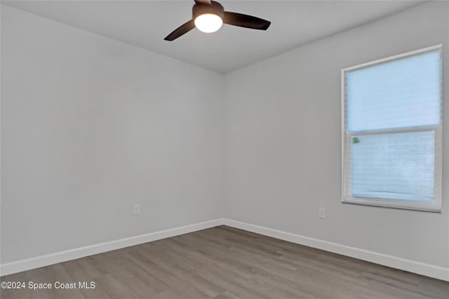 empty room with hardwood / wood-style flooring, ceiling fan, and a healthy amount of sunlight