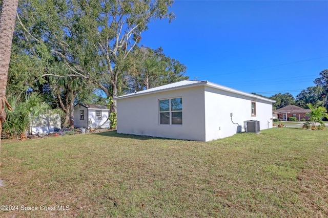 view of side of property featuring a lawn and central air condition unit