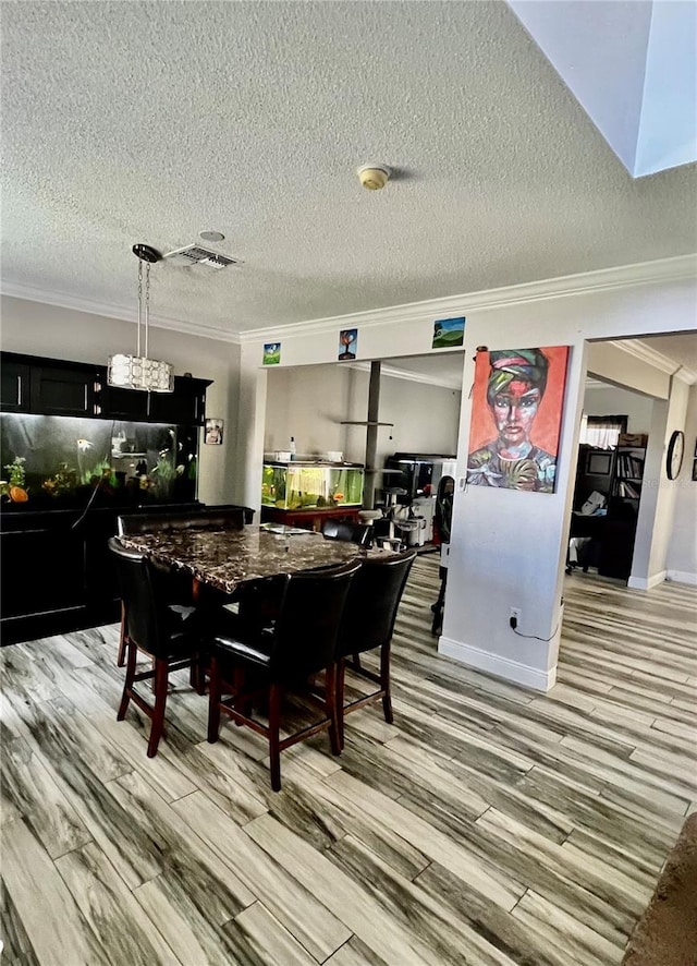 dining space with a textured ceiling, light hardwood / wood-style floors, and crown molding