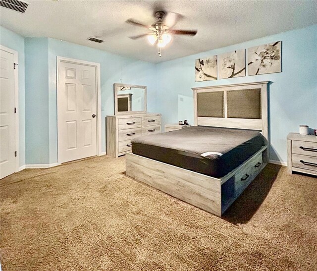 bedroom featuring carpet, ceiling fan, and a textured ceiling