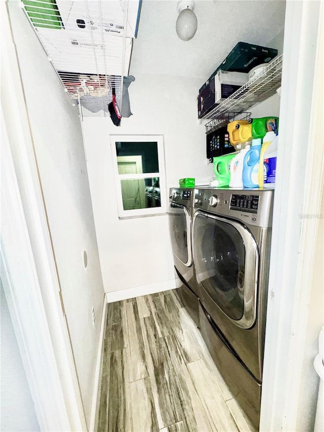 laundry room featuring hardwood / wood-style floors and washing machine and clothes dryer