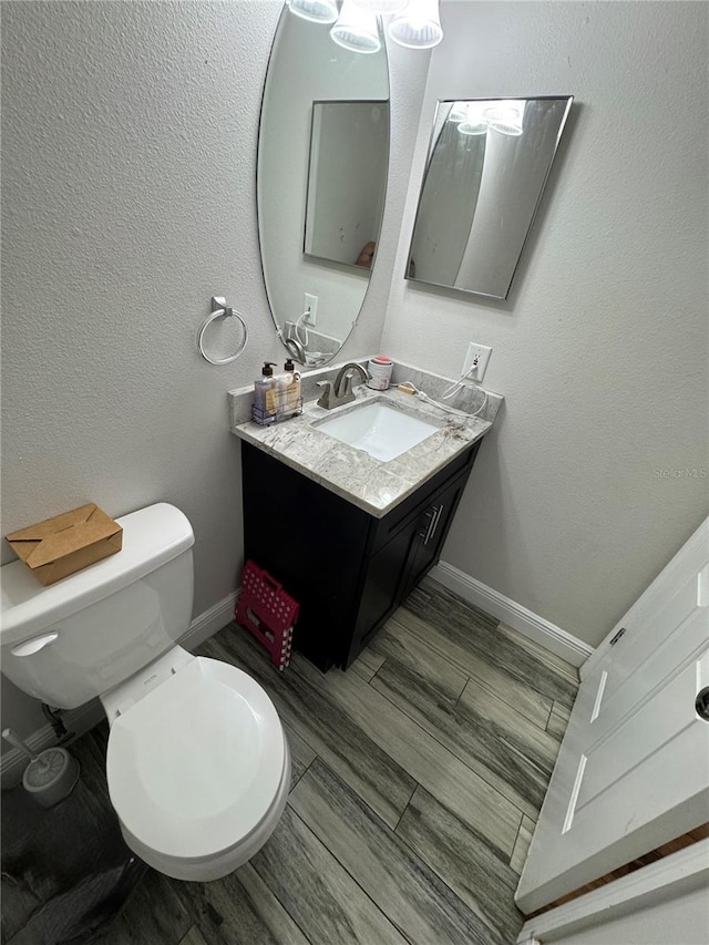 bathroom with hardwood / wood-style floors, vanity, and toilet