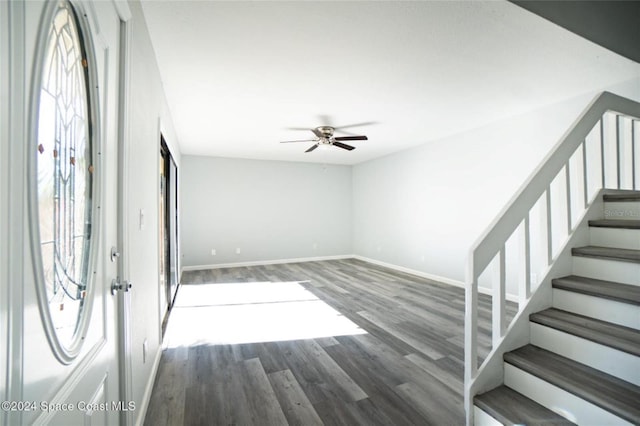 foyer entrance with ceiling fan and dark wood-type flooring