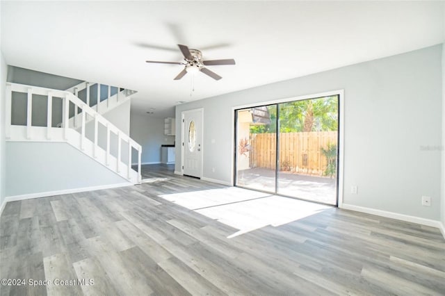 unfurnished living room featuring ceiling fan and light wood-type flooring