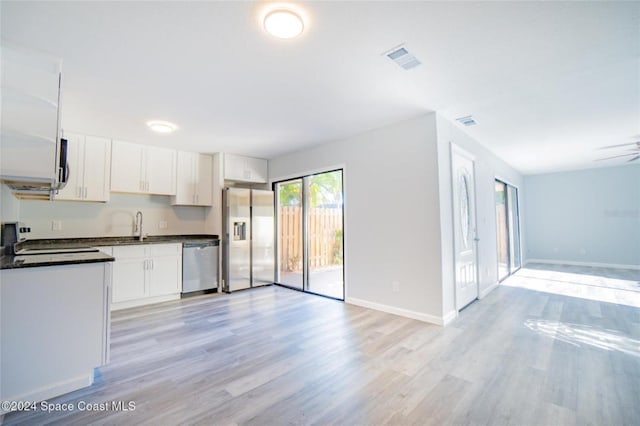 kitchen with white cabinets, ceiling fan, light wood-type flooring, and appliances with stainless steel finishes