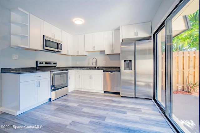 kitchen featuring white cabinets, stainless steel appliances, and light hardwood / wood-style flooring