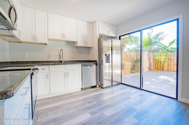 kitchen featuring light wood-type flooring, white cabinetry, and appliances with stainless steel finishes