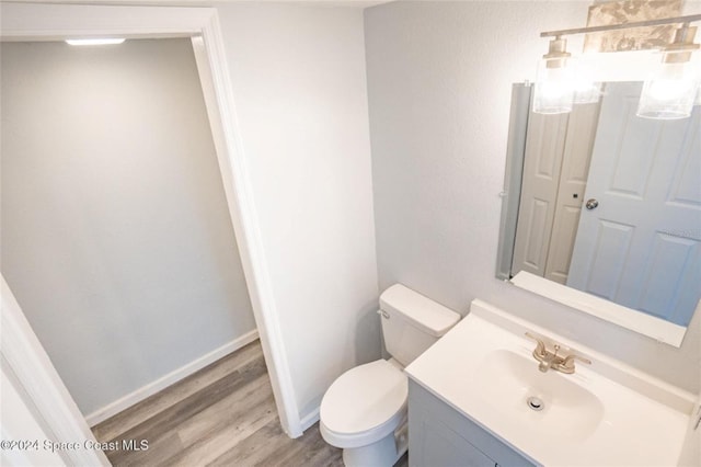 bathroom with vanity, hardwood / wood-style flooring, and toilet