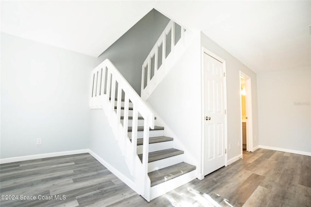 stairs featuring hardwood / wood-style floors