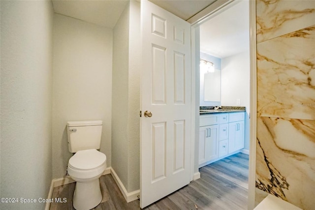 bathroom with hardwood / wood-style floors, vanity, and toilet