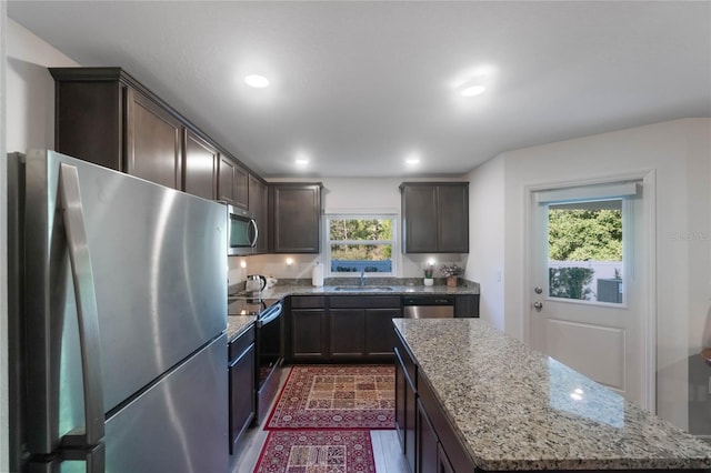 kitchen with a center island, sink, stainless steel appliances, and a wealth of natural light