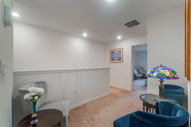 sitting room featuring light colored carpet