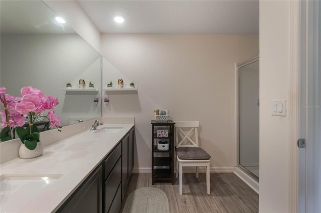 bathroom featuring hardwood / wood-style floors, vanity, and a shower with shower door