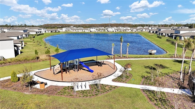 exterior space with a lawn, a playground, and a water view