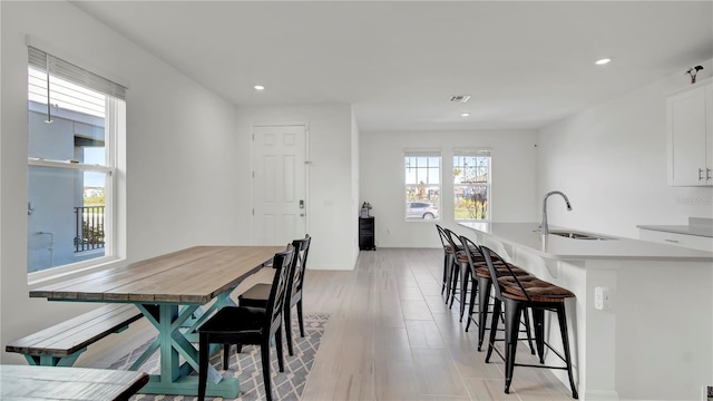 dining area with light hardwood / wood-style flooring and sink