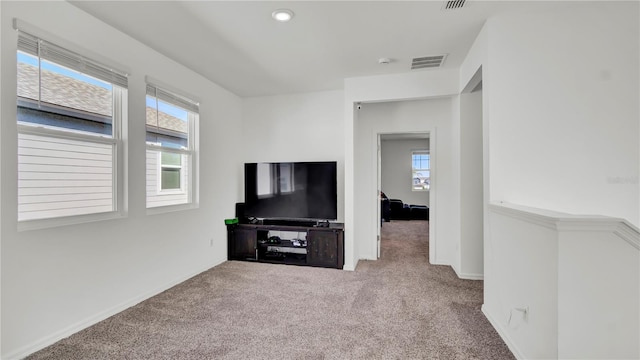 unfurnished living room with a wealth of natural light and carpet flooring