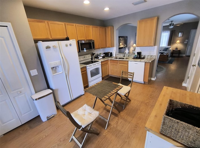 kitchen featuring light wood-type flooring, light brown cabinets, and white appliances