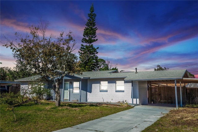 ranch-style home featuring a yard and a carport