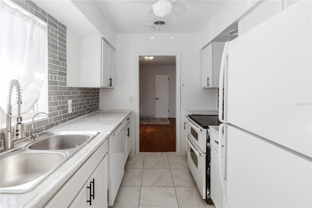 kitchen featuring white appliances, tasteful backsplash, white cabinetry, and sink