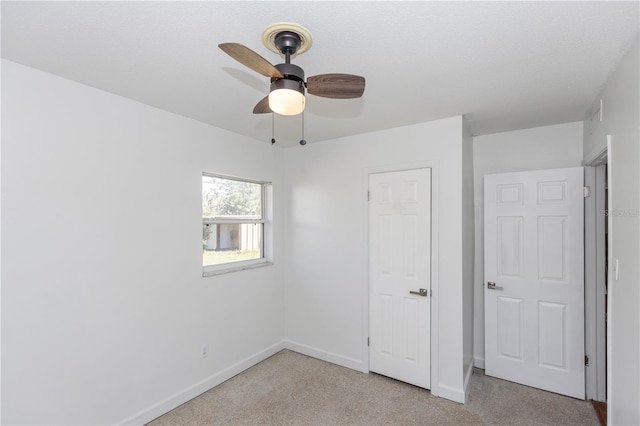 unfurnished bedroom with light carpet, a textured ceiling, and ceiling fan