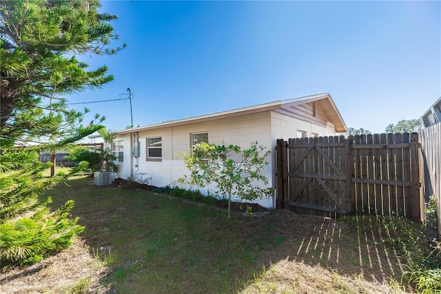 view of side of home featuring a yard and central AC unit