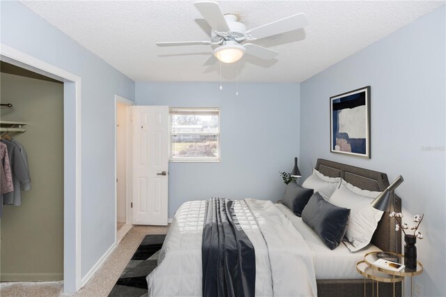 bedroom featuring a textured ceiling, a closet, light colored carpet, and ceiling fan