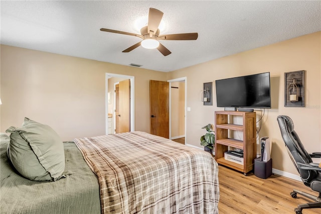 bedroom featuring a textured ceiling, light hardwood / wood-style flooring, and ceiling fan