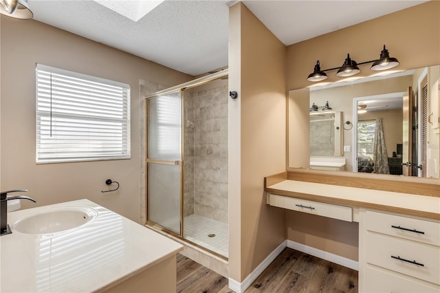 bathroom with wood-type flooring, vanity, a textured ceiling, and a shower with shower door