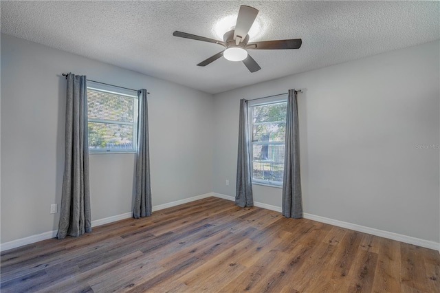 unfurnished room featuring a textured ceiling, ceiling fan, and dark wood-type flooring