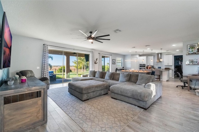 living room with light hardwood / wood-style flooring and ceiling fan