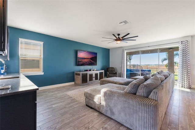 living room with ceiling fan and light hardwood / wood-style floors