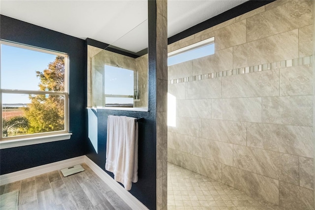 bathroom with hardwood / wood-style floors and a tile shower