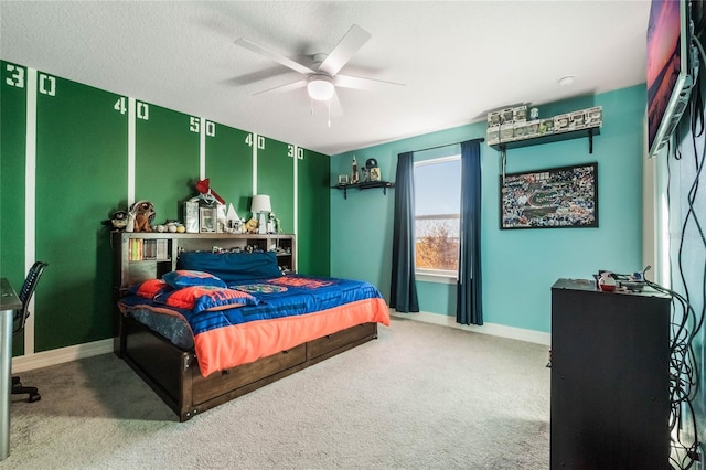 bedroom with ceiling fan, carpet, and a textured ceiling