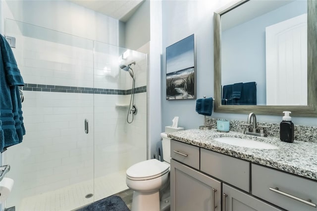 bathroom featuring vanity, toilet, and a shower with shower door