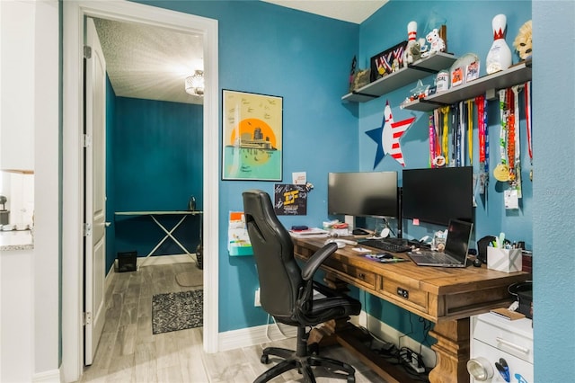 office area with a textured ceiling and light hardwood / wood-style flooring