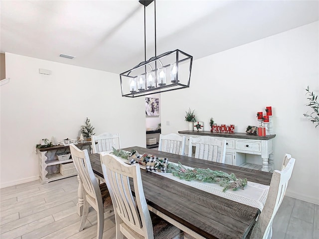 dining area with a notable chandelier and light wood-type flooring