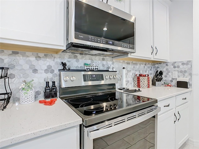 kitchen featuring tile patterned floors, decorative backsplash, white cabinetry, and stainless steel appliances