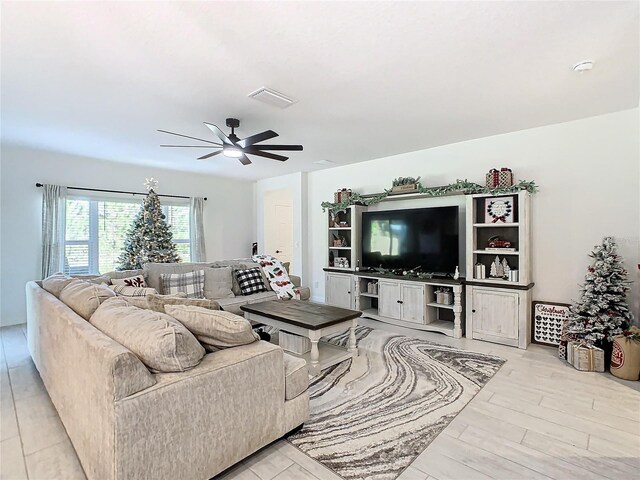 living room with light hardwood / wood-style floors and ceiling fan