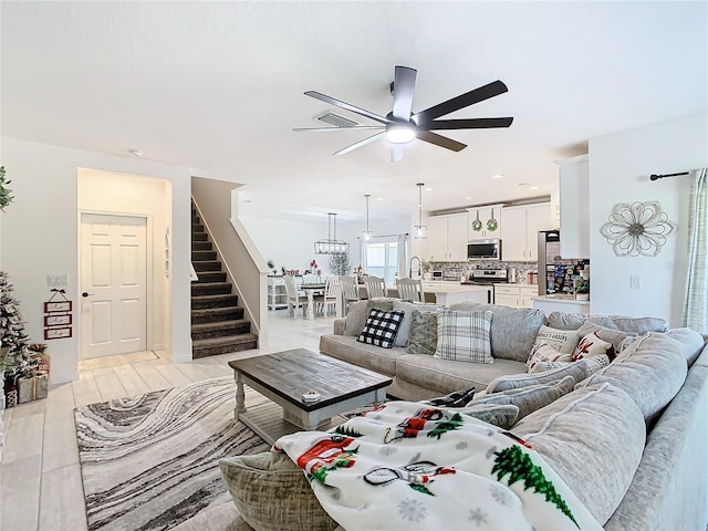 living room featuring light hardwood / wood-style flooring, ceiling fan, and sink