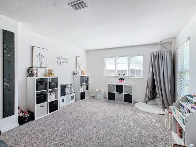 rec room featuring carpet flooring and a textured ceiling