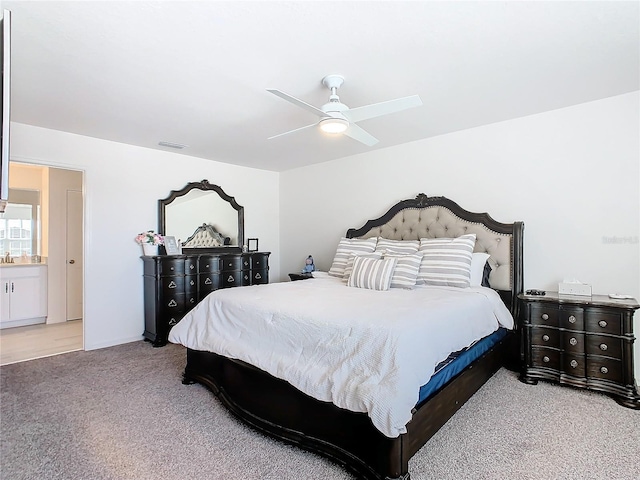 carpeted bedroom featuring connected bathroom and ceiling fan