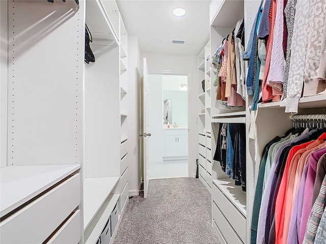 walk in closet featuring light colored carpet