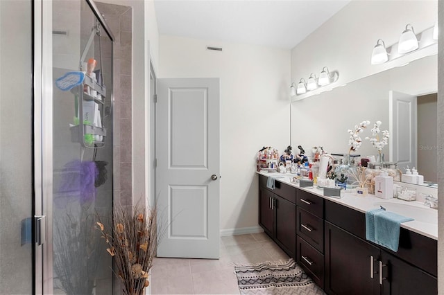 bathroom with tile patterned flooring, vanity, and walk in shower