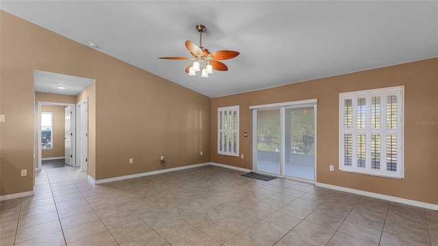 unfurnished room featuring ceiling fan, light tile patterned flooring, and lofted ceiling