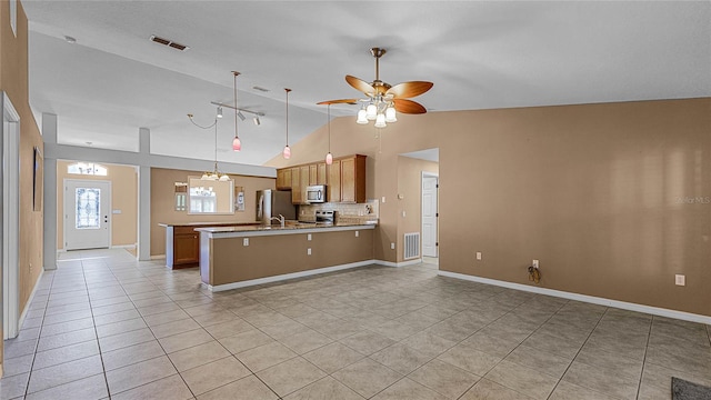 kitchen with kitchen peninsula, tasteful backsplash, stainless steel appliances, ceiling fan, and light tile patterned flooring