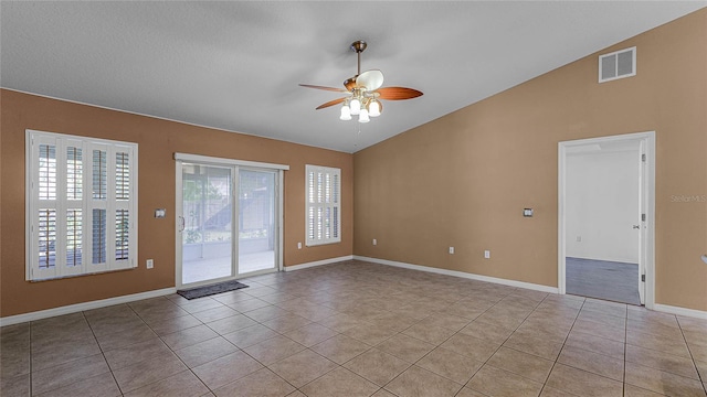 empty room with light tile patterned floors, vaulted ceiling, and ceiling fan