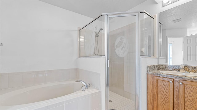 bathroom with vanity, independent shower and bath, and a textured ceiling