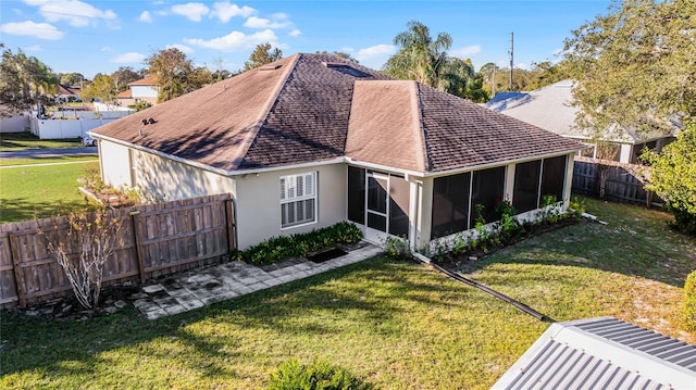 back of property featuring a yard and a sunroom