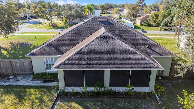 back of property with a lawn and a sunroom