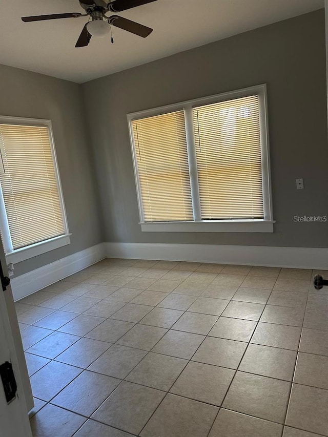 tiled spare room featuring ceiling fan